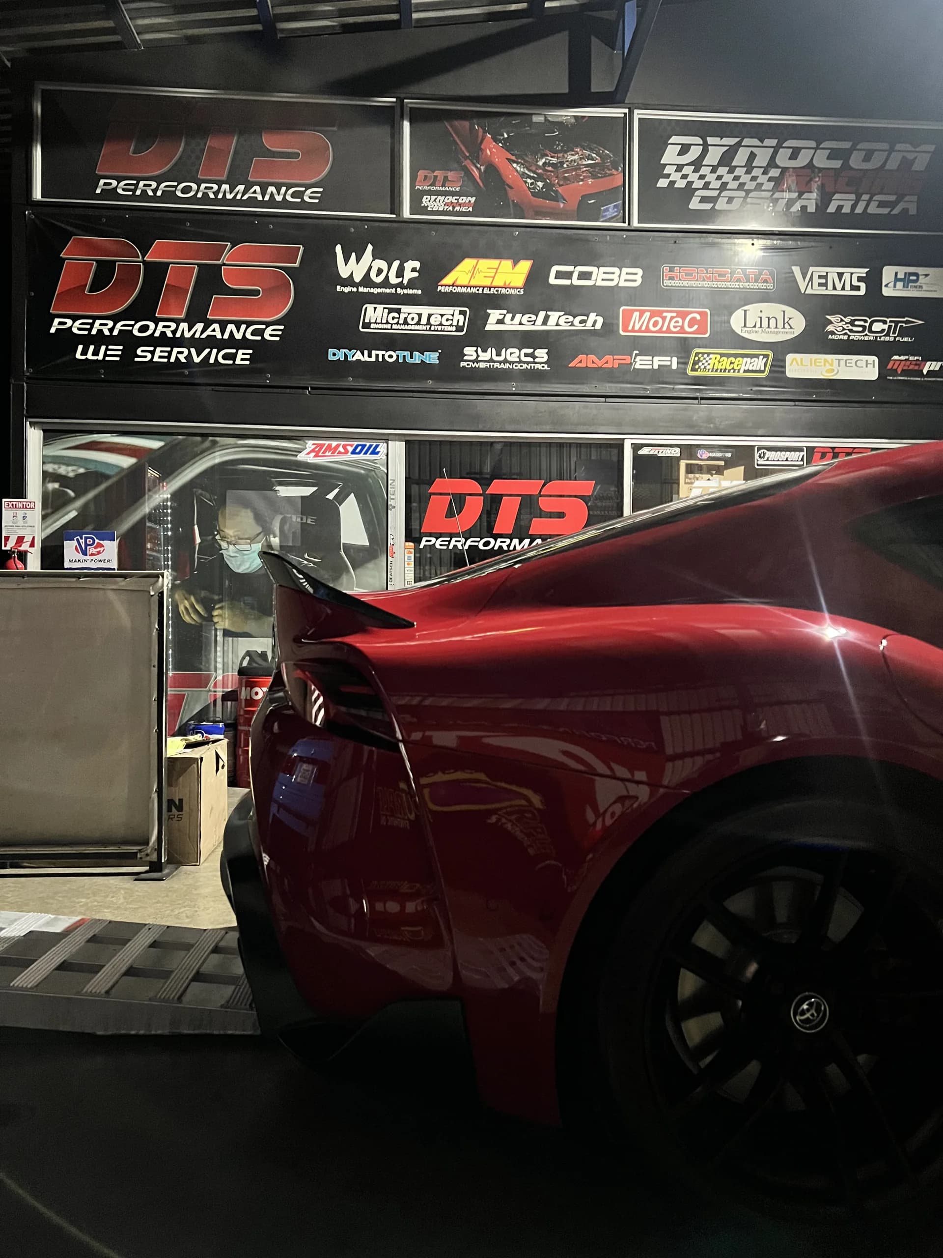 Supra roja sobre el dinamómetro DTS, frente al muro de marcas certificadas del taller